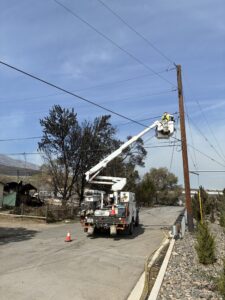 Photo of a utility truck working on a power line.